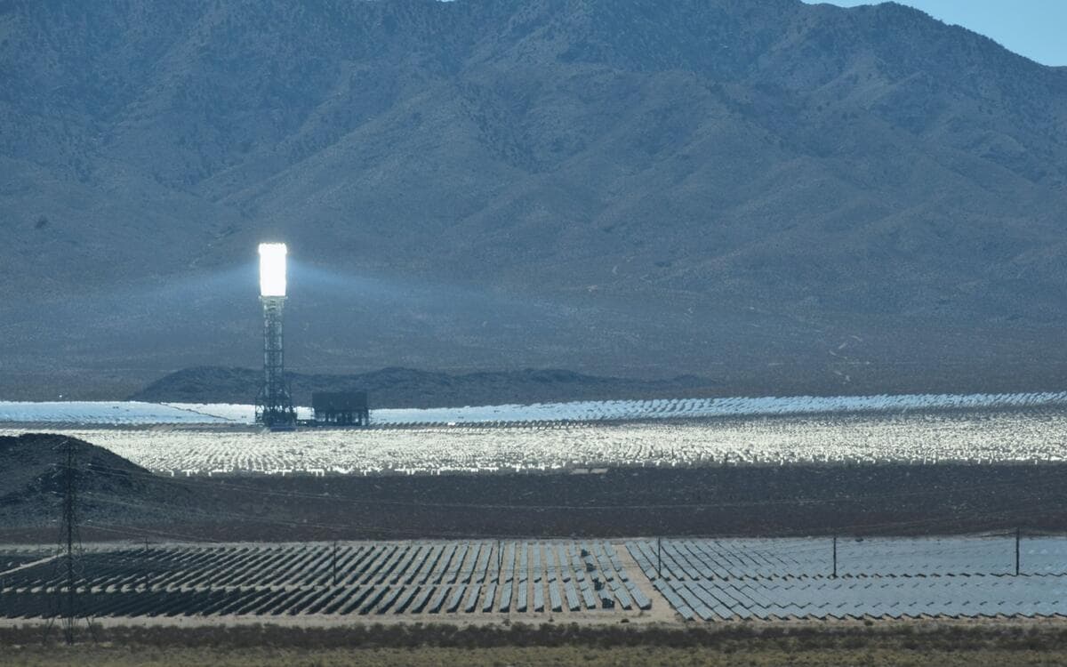 A concentrated solar generating facility set against a mountain range.